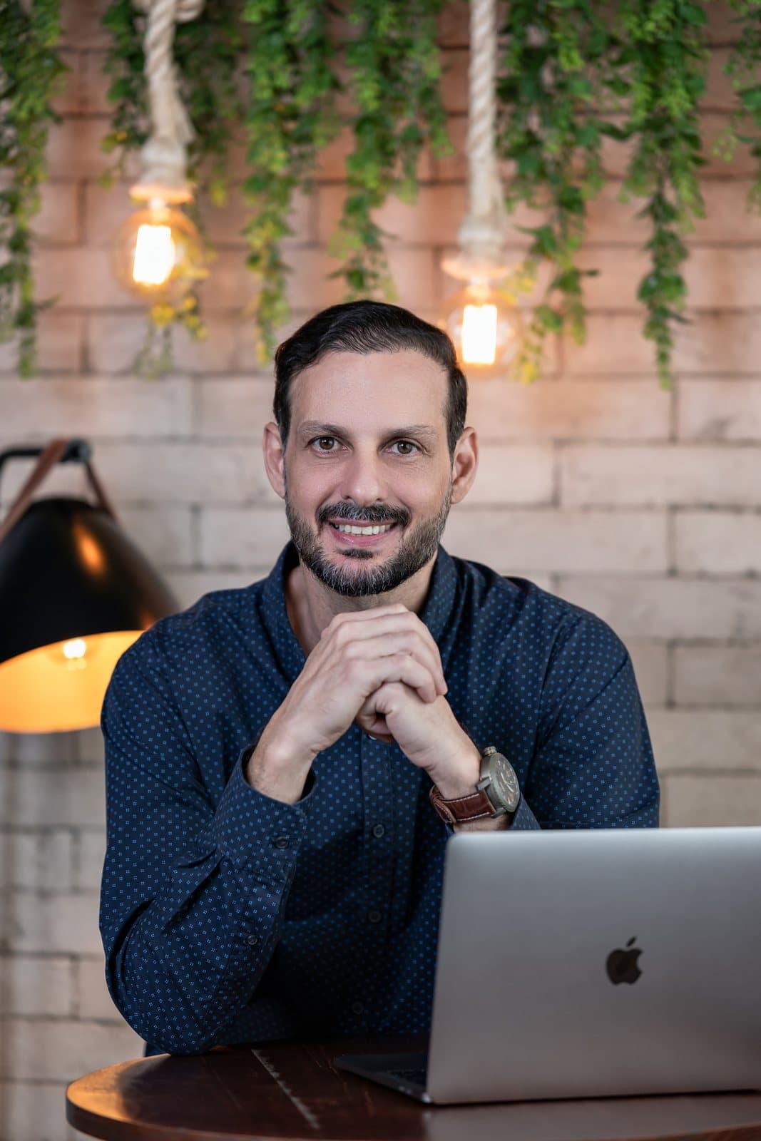 Davy Adame sorrindo, com luminárias ao fundo